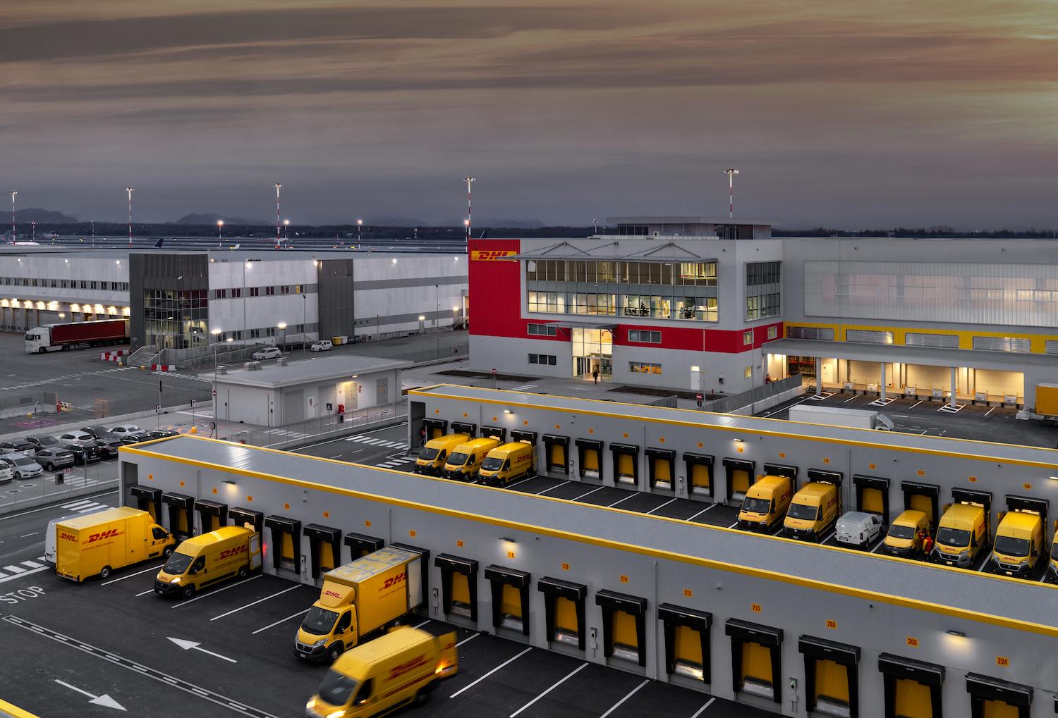 magazino dhl di grande dimensioni e camion di distribuzione medio-grandi